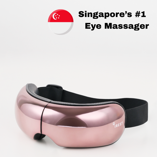 Rose gold eye massager with black strap on a white background, featuring Singapore's flag and text.